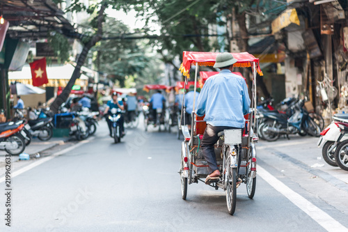 Traditional cyclo ride down the streets of Hanoi, Vietnam. The cyclo is a three-wheel bicycle taxi that appeared in Vietnam during the French colonial period.