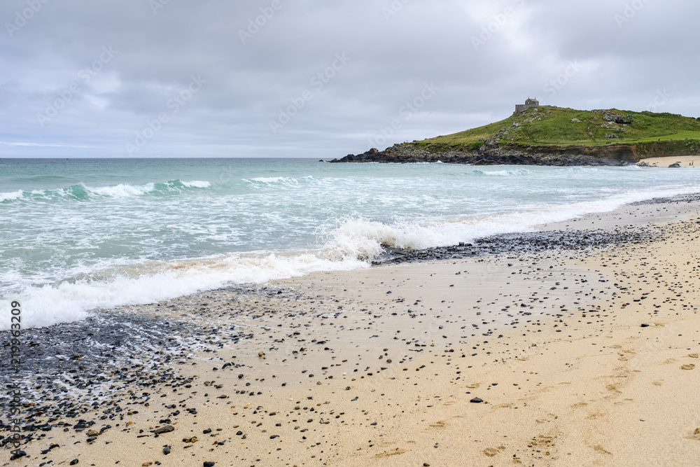 Rough sea crashing on the shore at Porthmeor beach, St Ives, Cornwall.