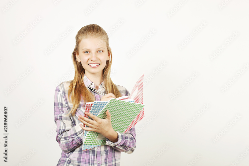 Beautiful casual blonde teenage girl with charming smile wearing plaid flannel shirt, holding bunch of notebooks & making notes. Back to school sale concept. Background copy space, close up, isolated Beautiful casual blonde teenage girl with charming smile wearing plaid flannel shirt, holding bunch of notebooks & making notes. Back to school sale concept. Background copy space, close up, isolated