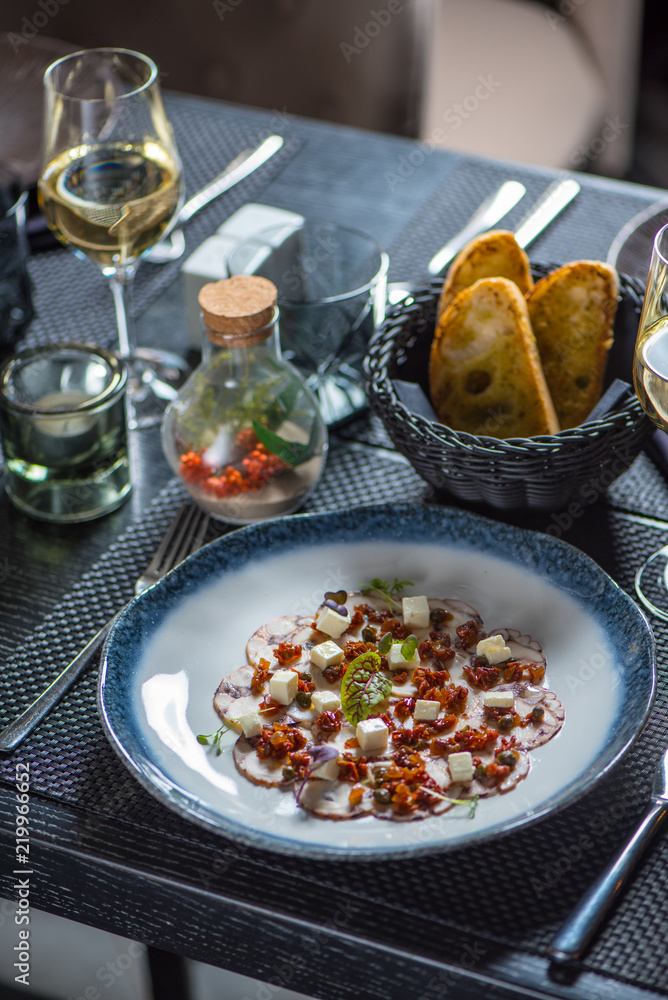 Carpaccio of octopus on blue plate Carpaccio of octopus on blue plate