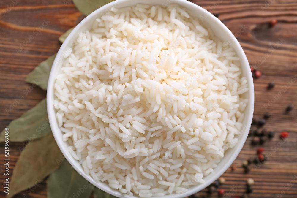 Bowl with boiled white rice on wooden table Bowl with boiled white rice on wooden table