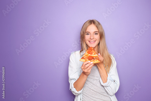 Young woman eating slice of...