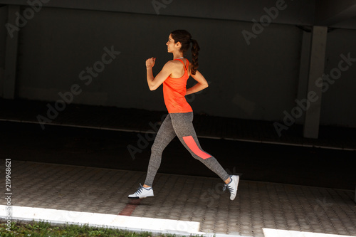 Female runner jogging trough parking lot.Fitness and jogging concept.