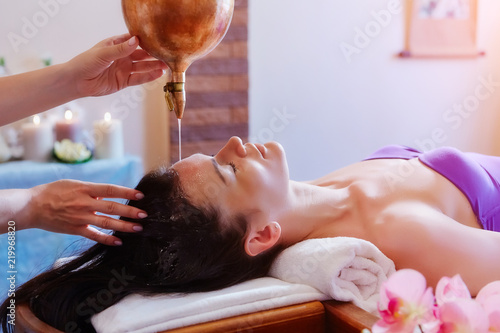 Caucasian woman having Ayurveda shirodhara treatment