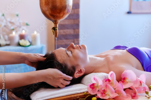 Young woman having pouring oil massage  spa treatment. Shirodhar
