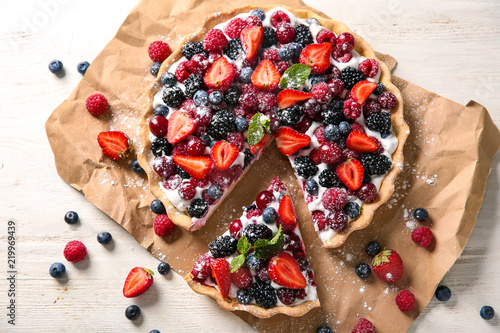 Delicious pie with ripe berries on table, top view
