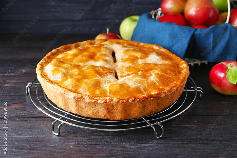 Cooling rack with delicious apple pie on wooden table Stock Photo ...