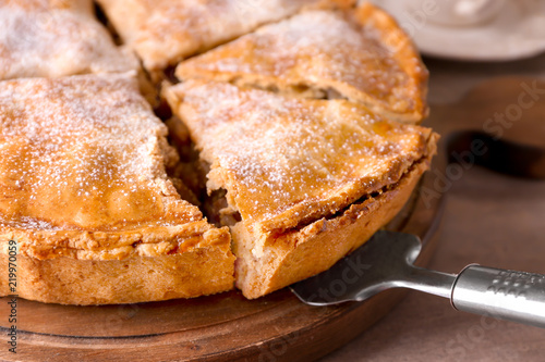 Delicious apple pie with piece on shovel, closeup