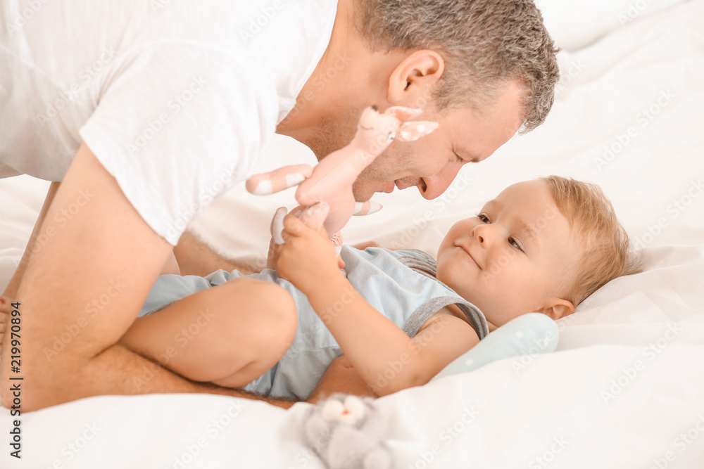 Father playing with his little son in bedroom Father playing with his little son in bedroom