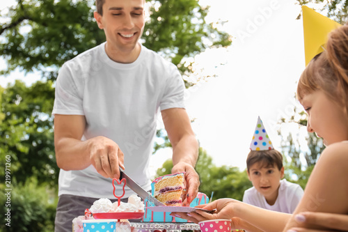 Father putting piece of cak...