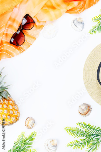 Tropical summer concept with woman fashion accessories, leaves and pineapple on white background. Flat lay, top view