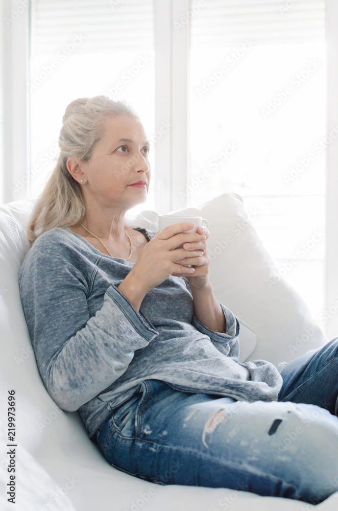 Adult woman sitting and holding cup