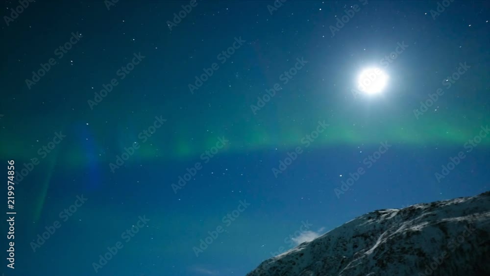HD Time-lapse of Northern Light Aurora Borealis in the night sky over Senja island in Northern Norway. Snow covered mountains in the background where moonlight is illuminating landscape. HD Time-lapse of Northern Light Aurora Borealis in the night sky over Senja island in Northern Norway. Snow covered mountains in the background where moonlight is illuminating landscape.