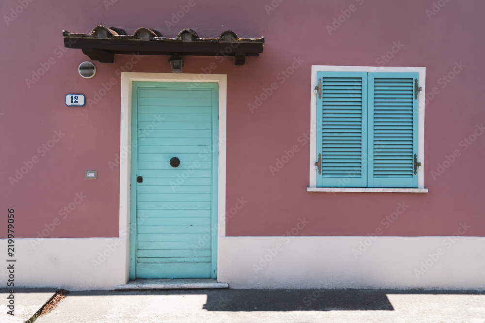 old house wall with blue wooden door and window