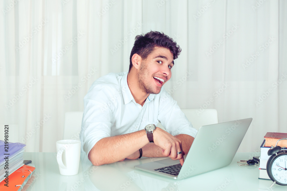 Cheerful smart man with laptop in office Cheerful smart man with laptop in office