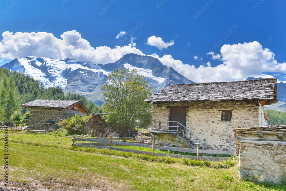 village in the valley next to alpine glacier in summer village in the valley next to alpine glacier in summer