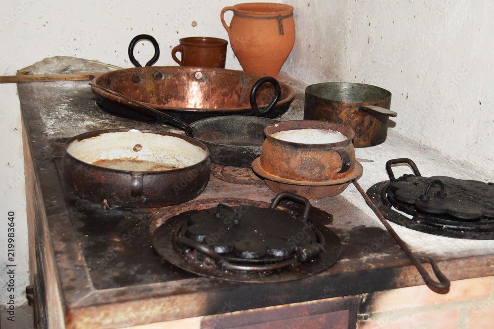 metal brass pots for cooking dishes on a wood and coal kitchen, a medieval cottage metal brass pots for cooking dishes on a wood and coal kitchen, a medieval cottage