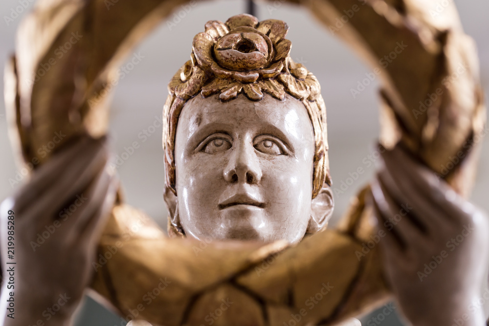Face of an old angel with golden ornaments