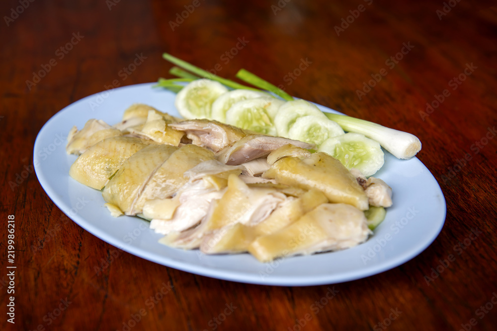Steamed chicken fillet on a plate with a slice of cucumber to eat a meal with rice and sauce