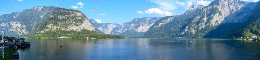 Panoramic views of the Alpine lake and the town of Hallstatt, surrounded by mountains.