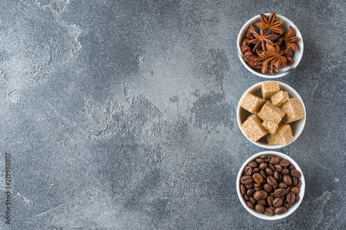 Brown sugar cubes, coffee beans and star anise on concrete background. Copy space