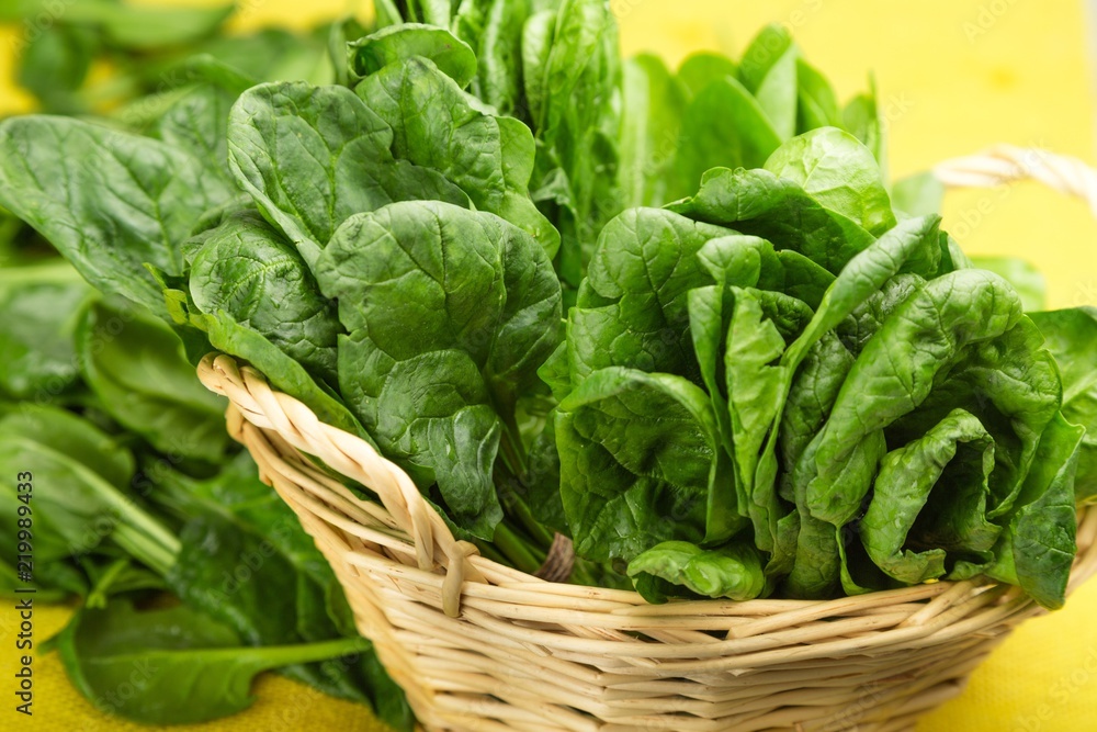 Young Spinach Leaves In Basket And More On Yellow Tablecloth Young Spinach Leaves In Basket And More On Yellow Tablecloth