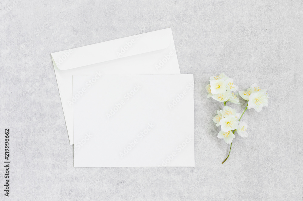 Grey background with blank postcard and flower Grey background with blank postcard and flower