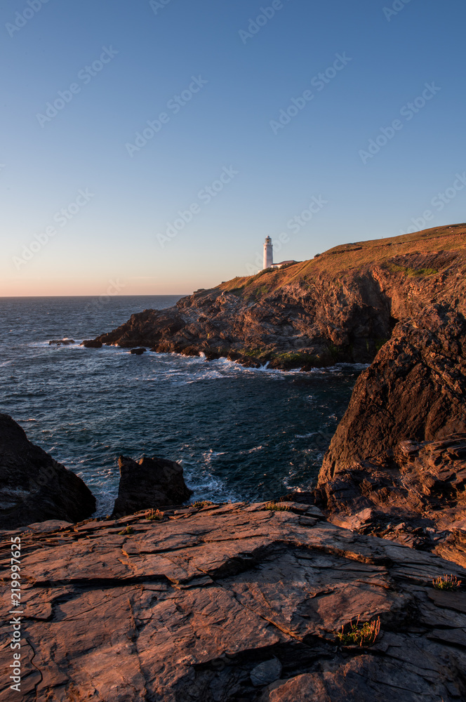 Lighthouse on a rocky shore sunset