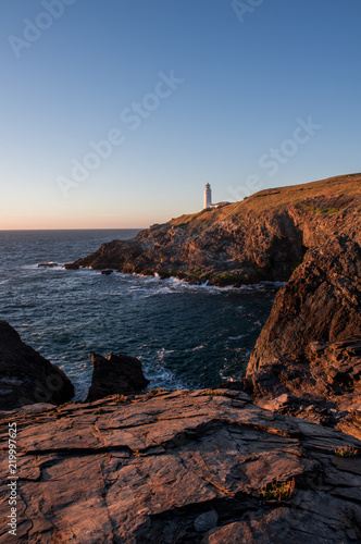 Lighthouse on a rocky shore sunset