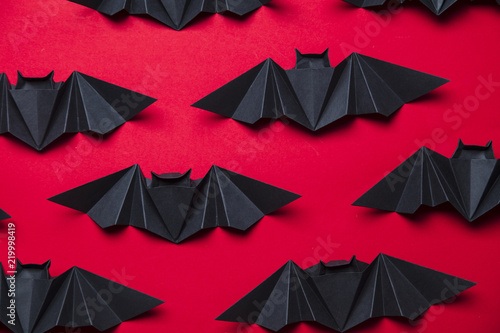 Photo Halloween bats made from paper on a red background
