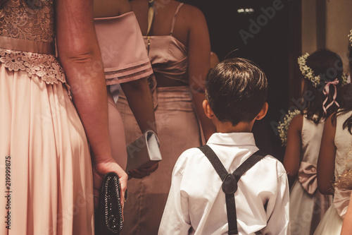 Cute ring bearer and the bridemaids preparing to enter to the church. photo