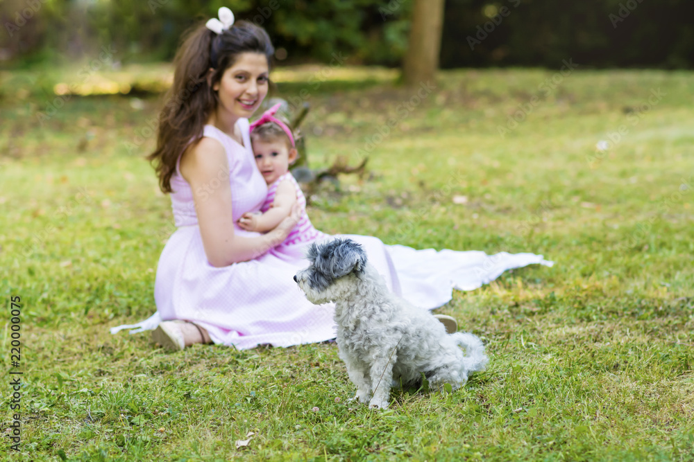 Happy Mother with her Baby Girl and her Dog in the Summer Park .Mother and Daughter .Happy Family, Mother with Little Child Happy Mother with her Baby Girl and her Dog in the Summer Park .Mother and Daughter .Happy Family, Mother with Little Child