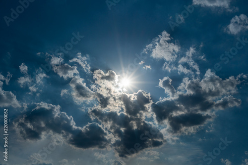 Beautiful blue sky background, sunrays through the clouds
