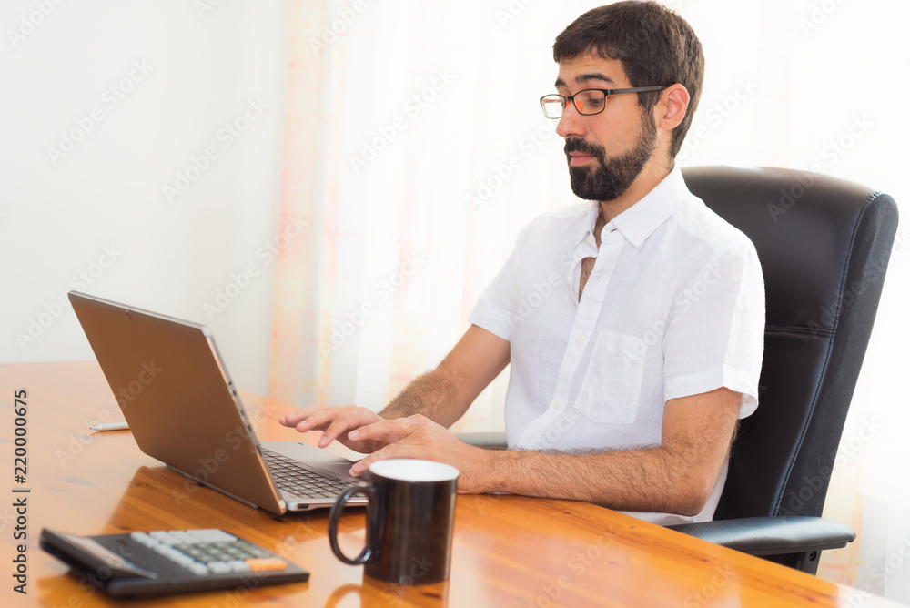 Portrait of a handsome hipster guy working at the office Portrait of a handsome hipster guy working at the office