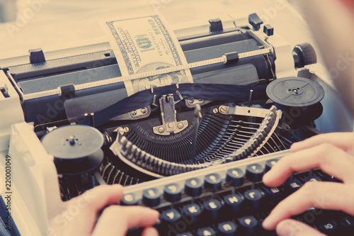 Money being typed out in a manual typewriter as symbol of inflation, global financial crisis and uncertain future of international trade and investment.