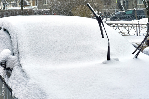 cold winters in a snow-covered car prudently lifted the windshield wipers that would not have fallen to the glass