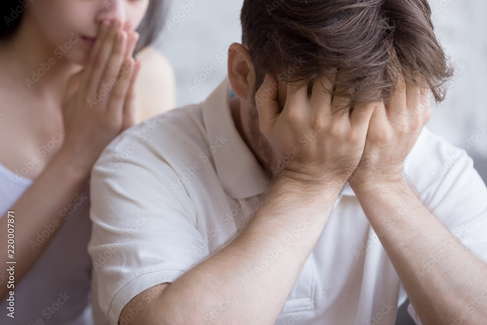 Upset millennial man feel desperate and down having problems at work or business, young girlfriend try to caress or show support, frustrated confused wife attempt to calm or comfort husband. Close up Upset millennial man feel desperate and down having problems at work or business, young girlfriend try to caress or show support, frustrated confused wife attempt to calm or comfort husband. Close up