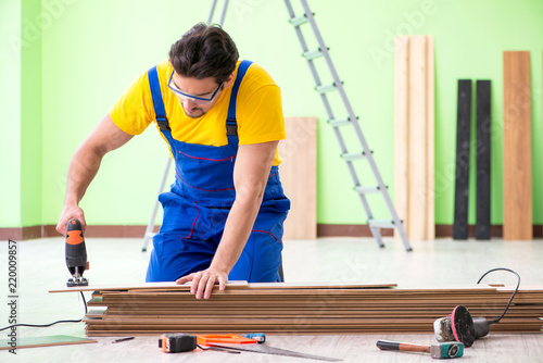 Professional contractor laying flooring at home © Elnur