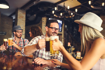 Fotobehang Kroeg Vrolijke vrienden drinken bier in kroeg  © lordn