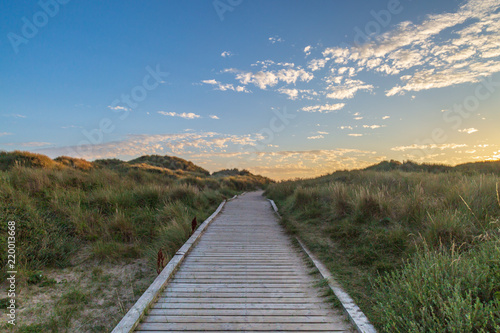 A wooden pathway leading towards the sea at Formby in Merseyside  taken at sunset