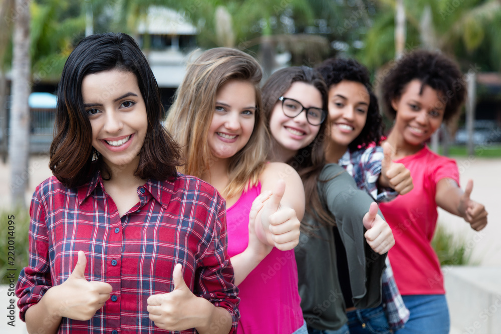 Obraz premium Arabic woman showing thumb with group of girlfriends