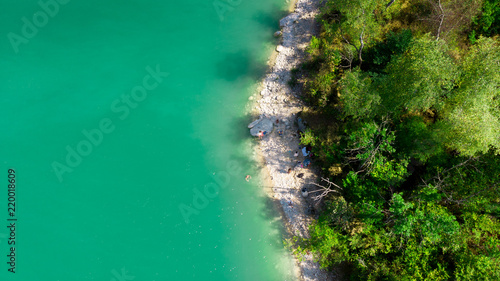 vue aérienne sur une plage au bord d'un lac à la couleur verte émeraude