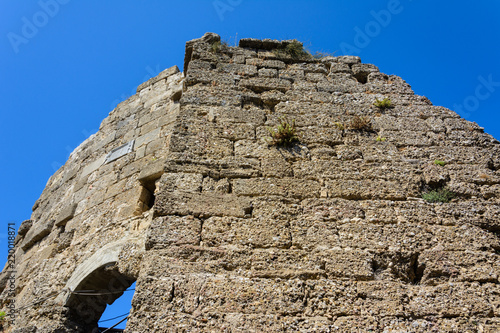 stone ruins of the walls of ancient Thermae with arch on blue sky background