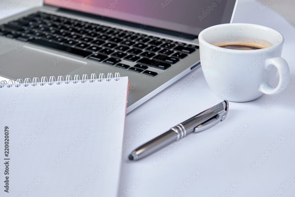 Modern white office desk table with laptop computer, pen, notebook and cup of coffee. Working desk table concept. Modern white office desk table with laptop computer, pen, notebook and cup of coffee. Working desk table concept.