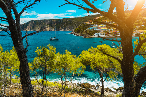 Beautiful bay with picturesque sea water surrounded by pine trees. Assos village Mediterranean Sea, Greece. Summer vacation on Greek Island photo