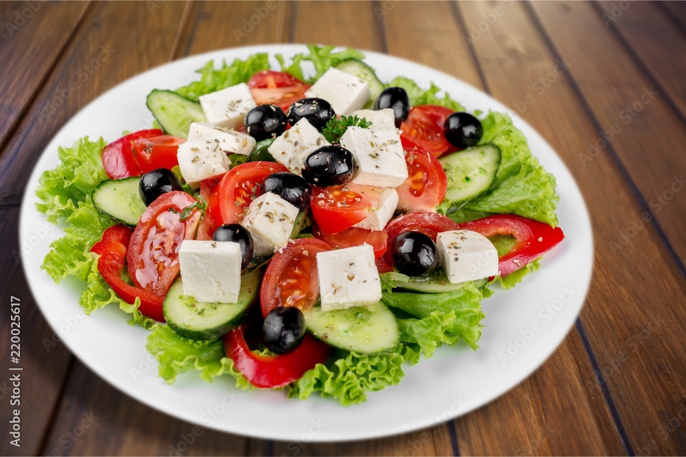 Greek salad with fresh vegetables on background