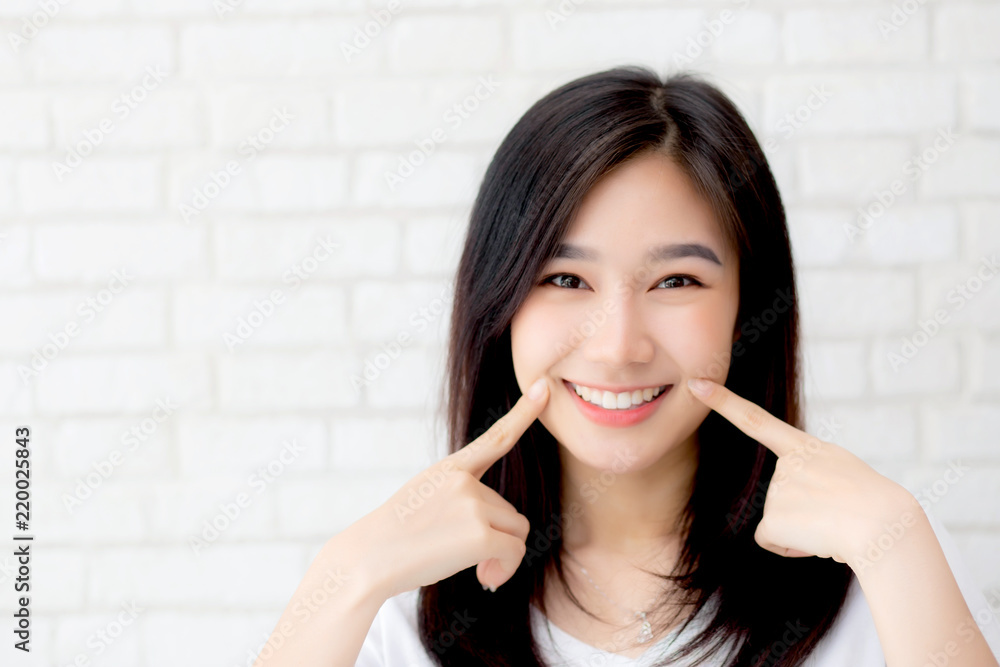 Portrait of beautiful young asian woman happiness standing finger touch cheek on gray cement texture grunge wall brick background, businesswoman is a smiling on concrete, business people concept. Portrait of beautiful young asian woman happiness standing finger touch cheek on gray cement texture grunge wall brick background, businesswoman is a smiling on concrete, business people concept.