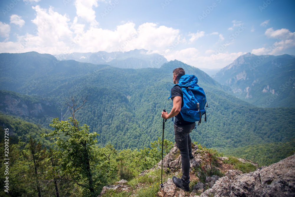 Hiker on a top of mountain looking at awesome view