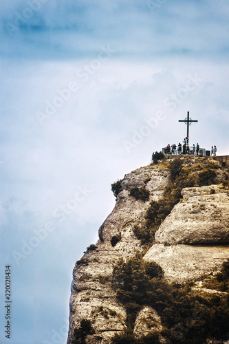 Saint Michael s cross in Montserrat  Barcelona against a cloudy sky. Travel destination and religious symbol with empty copy space for Editor s text.