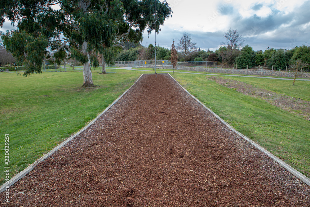 Shredded bark chip mulch provides a safe landing area for children under a flying fox in a playground